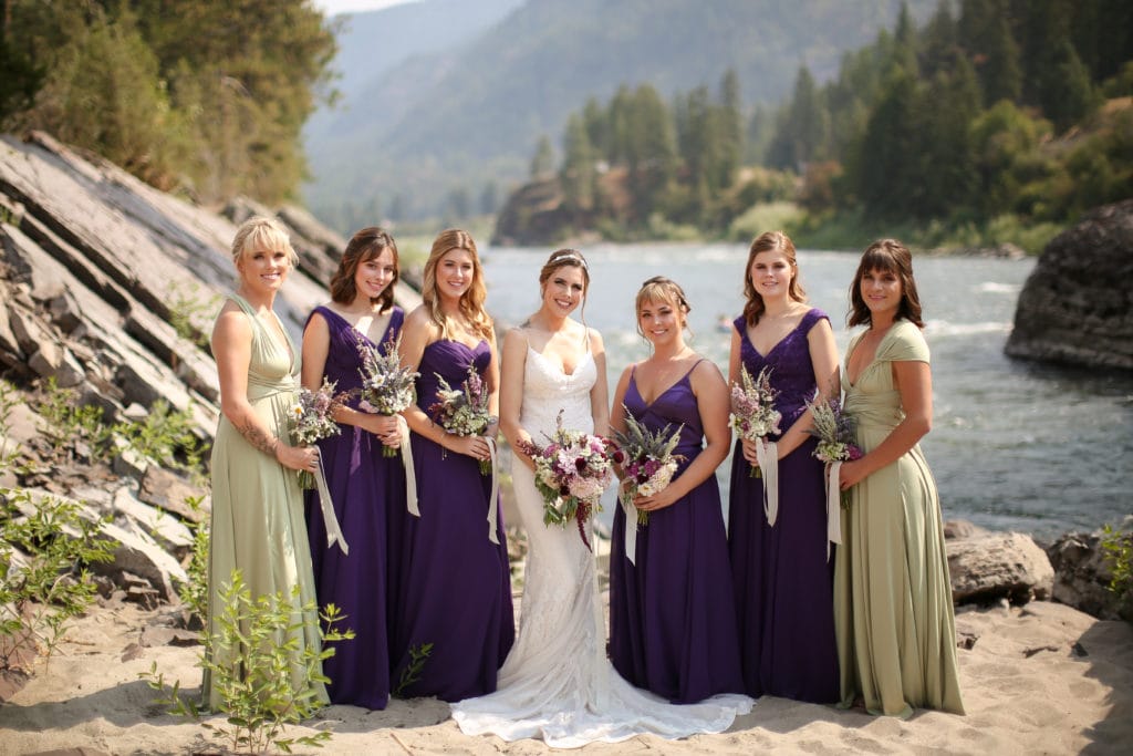 bride with her bridesmaids holding their bouquets standing infront of the alberton gorge at white raven avenue in alberton, Montana