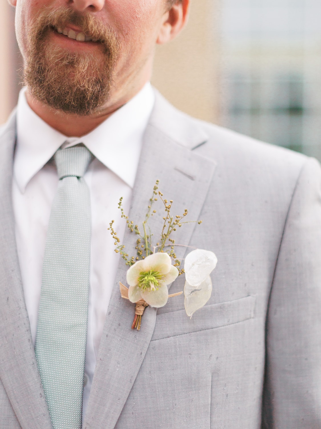 Groom wearing gray suit with boutonniere in Missoula wedding