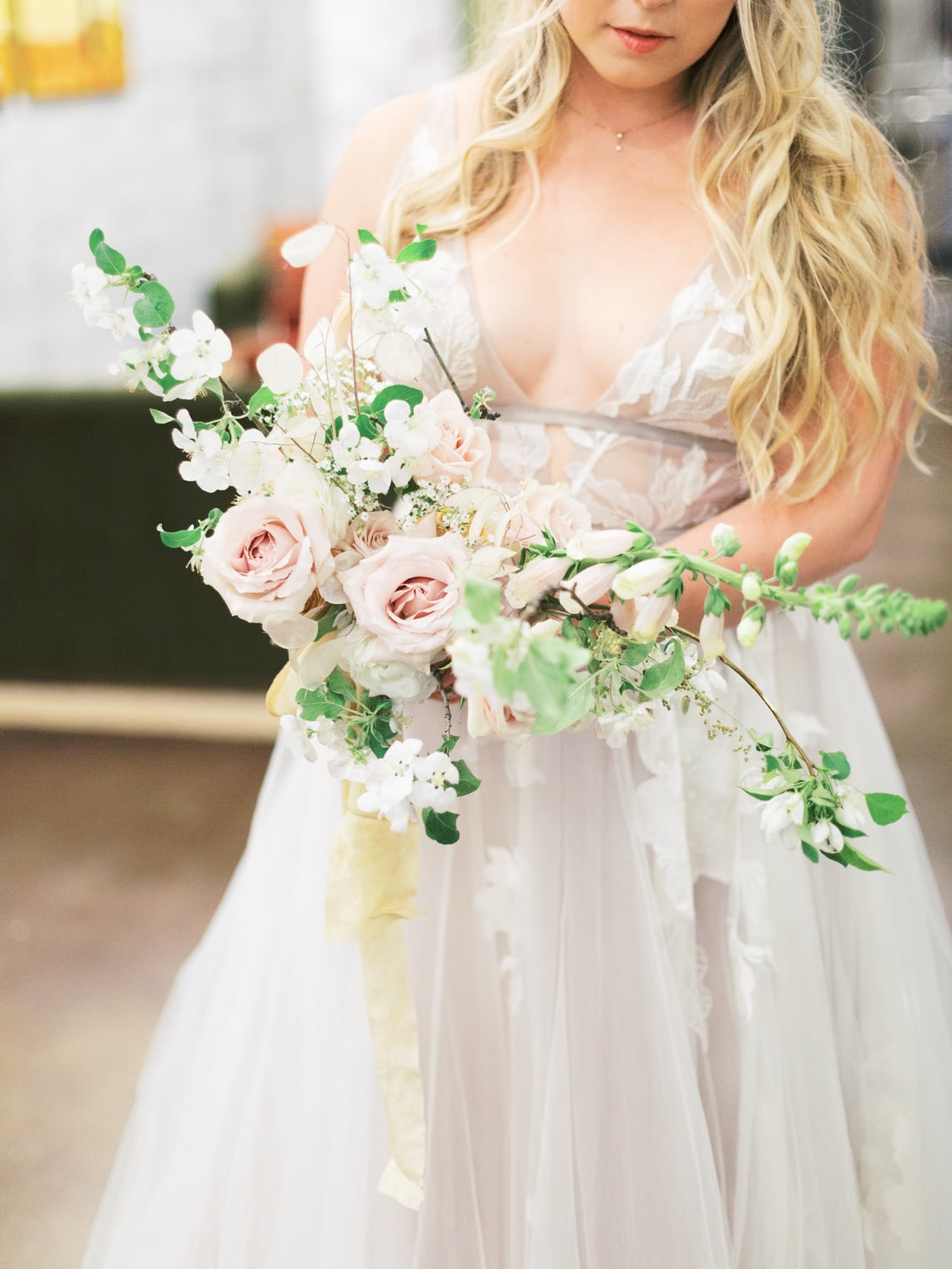 Bride holding bouquet of dried flowers, hellebore, and roses