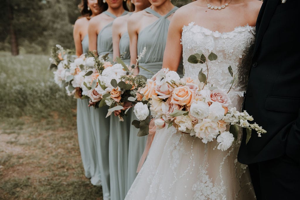 bride and bridesmaids lined up showing off bouquets